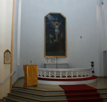 Syvänniemen kirkon alttari, seinällä alttaritaulu, jossa Jeesus ristillä.