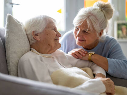 Elderly woman with her caregiver at nursing home.