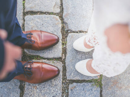 The feet of a bride and groom standing opposite each other.