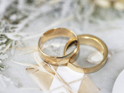 Two golden wedding rings, partially on top of each other.