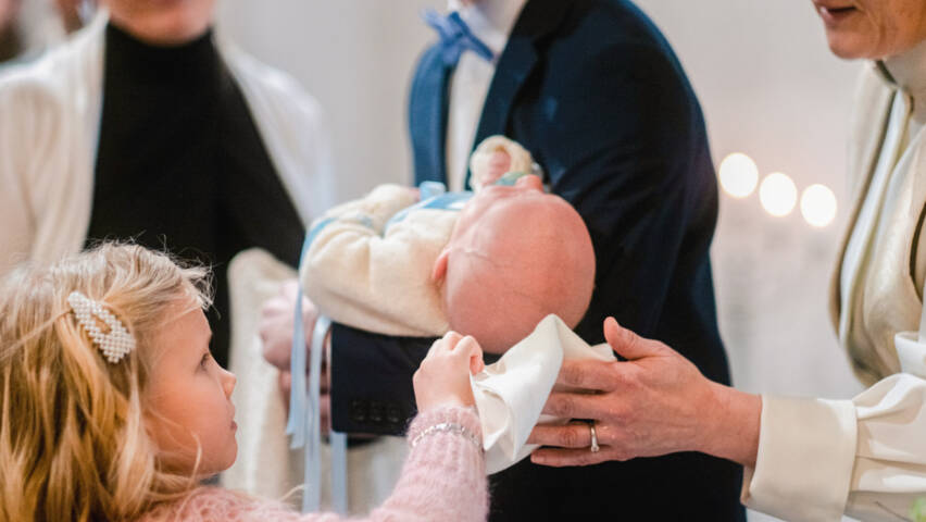 A pastor baptises a child.