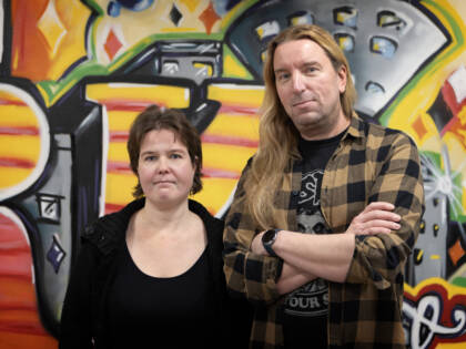 Metal Kingdom -toiminnan vetäjät poseeraavat tägiseinän edessä.