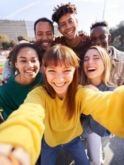 Joukko iloisia nuoria ottamassa selfietä porukasta.