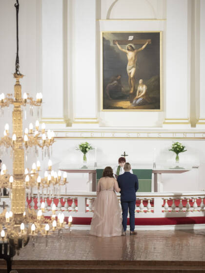 Hääpari ja pappi Tuomiokirkon alttarilla.