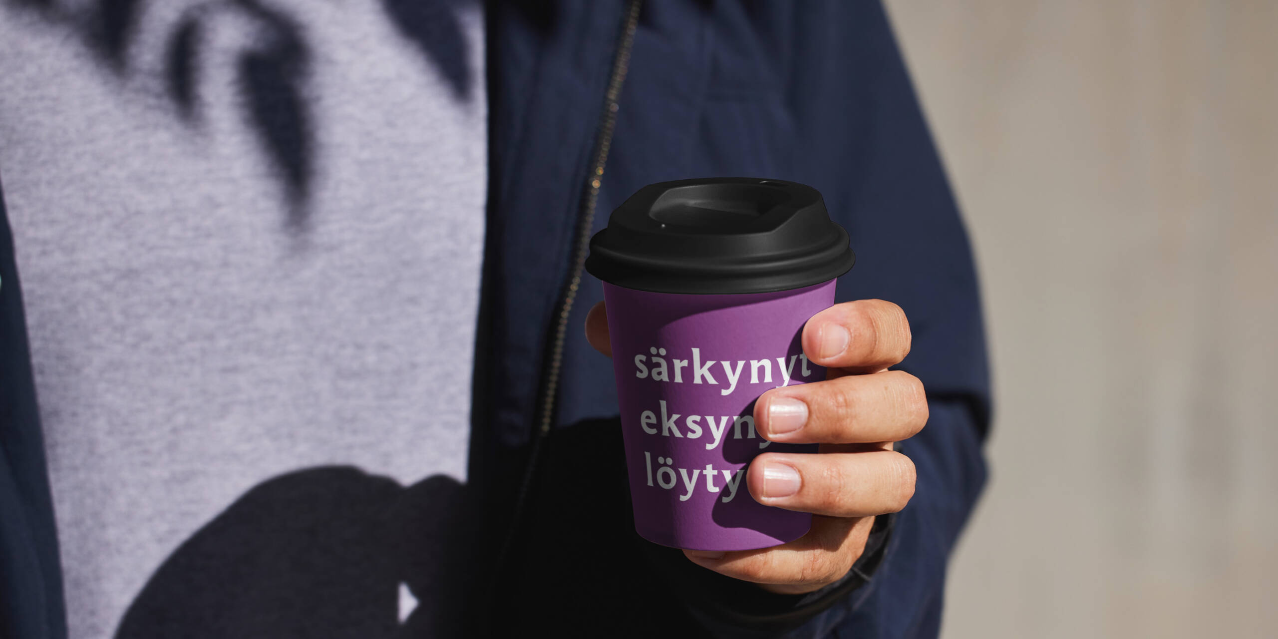 Henkilö kahvimuki kädessä. Mukissa seurakuntavaalien mainosteksti.