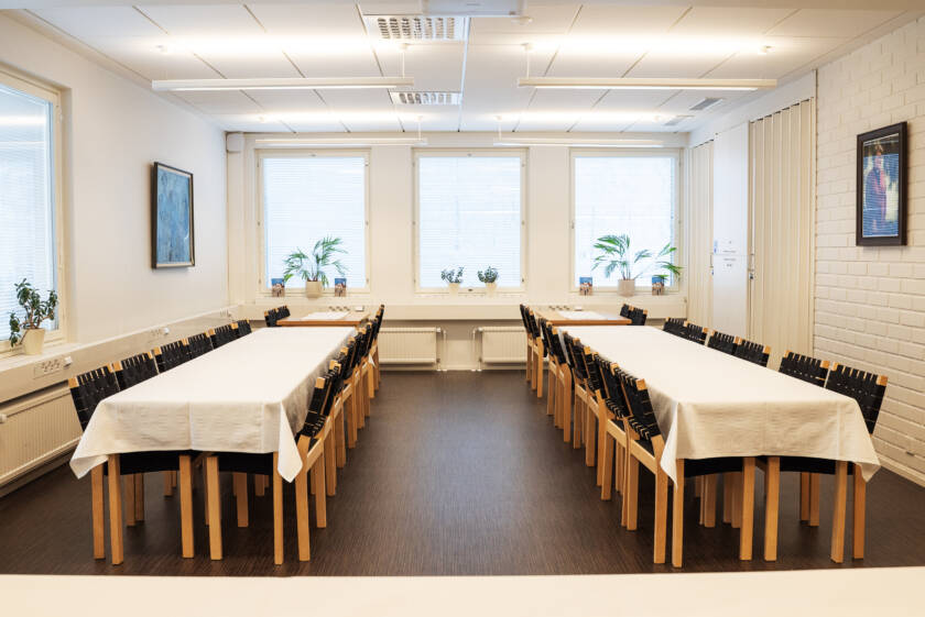 Kaksi pitkää pöytää huoneessa.