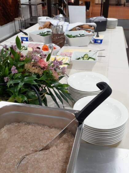 Ruispuurokattila pöydällä, jossa lautasia ja muuta tarjottavaa.