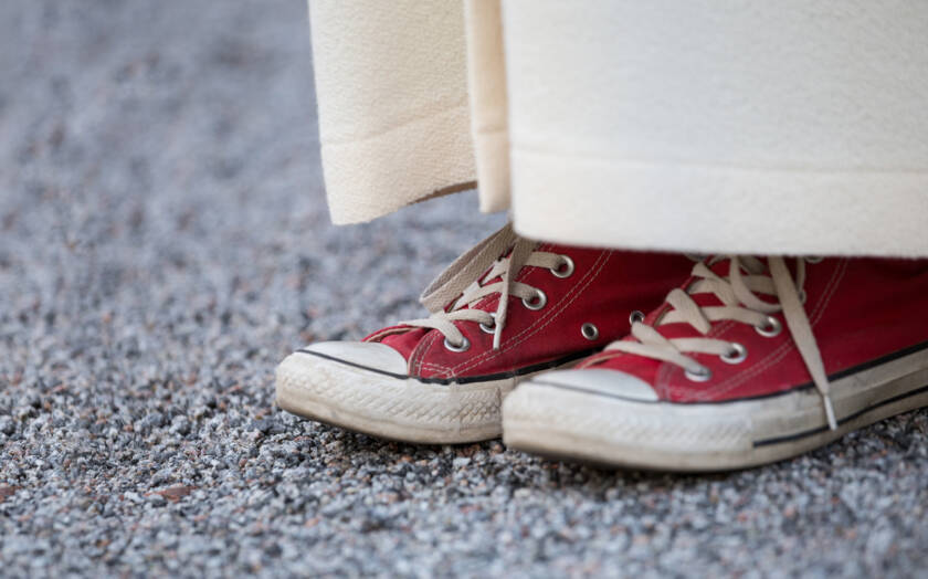 Nuori punaisissa Converse-tennareissa. Tennarit näkyvät alban alta lähikuvassa.
