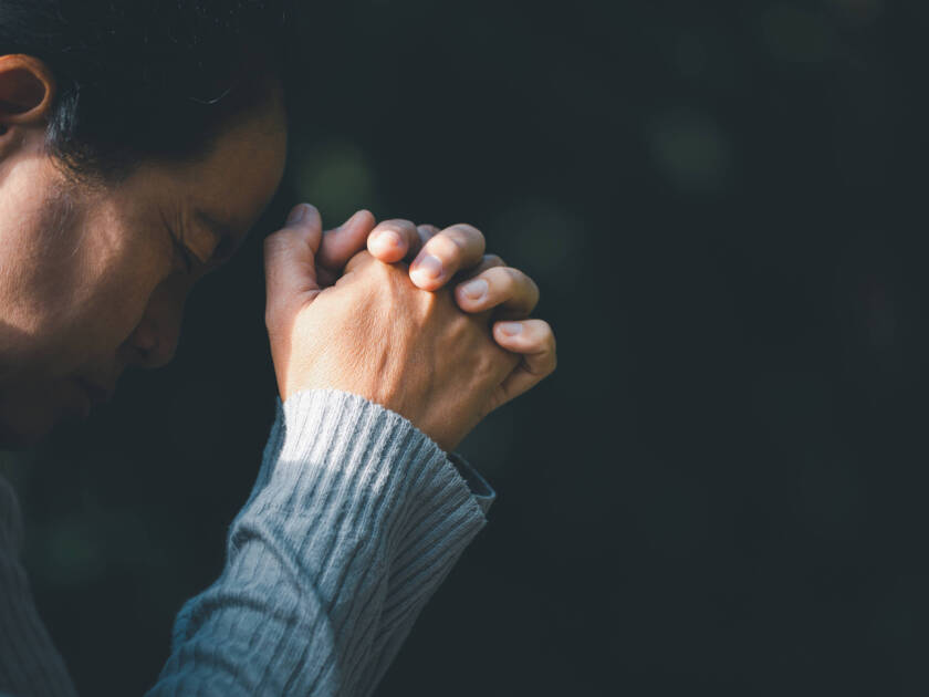 Prayer person hand in black background.
