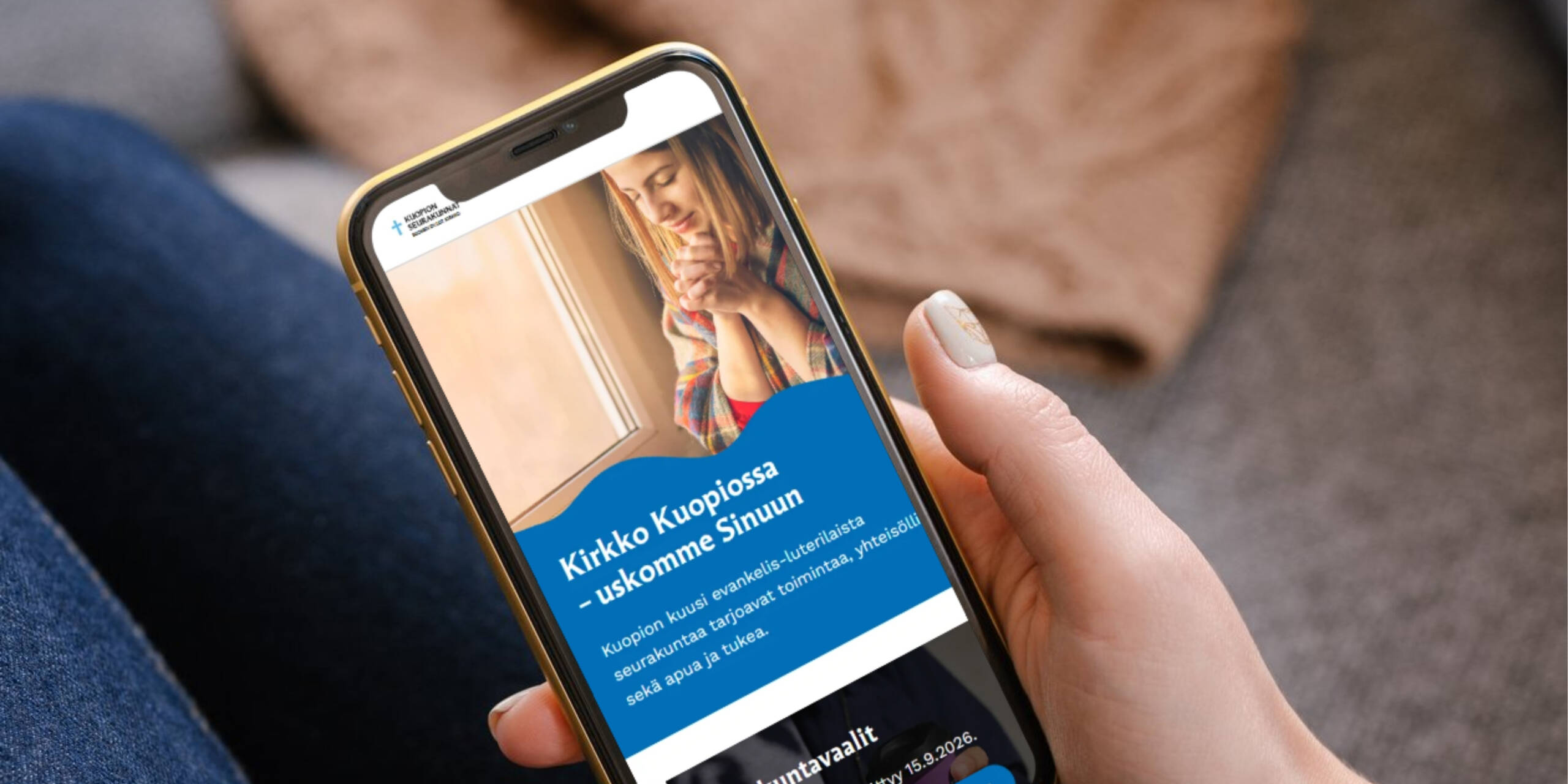 Lähikuva kädessä olevasta kännykästä. Kännykässä avoimena uudistunut Kuopion seurakuntien etusivu.