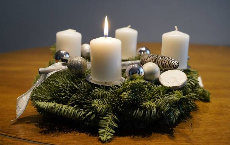 Neljä adventtikynttilää, joissa yhdessä liekki havu seppeleessä.