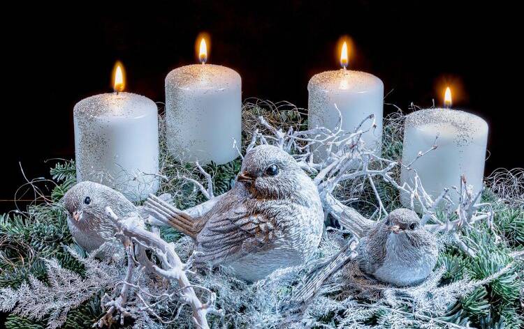 Neljä adventtikyntillää liekillä, somisteessa kolme lintua ja oksia.