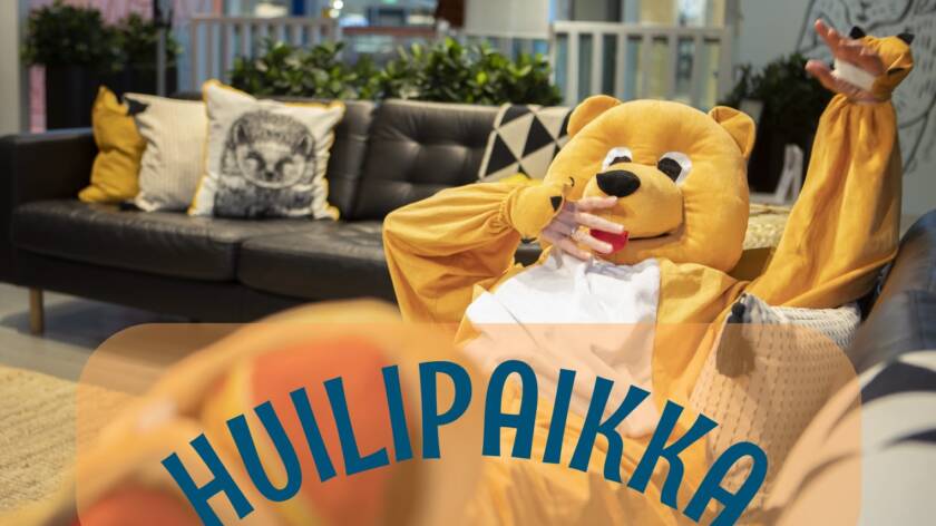 Kuvassa nalleasuun pukeutunut henkilö loikoilemassa sohvalla.