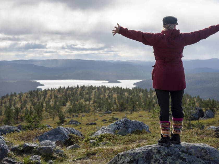 Vaeltaja Lapissa kiivennyt tunturiin ja ihailee maisemaa.