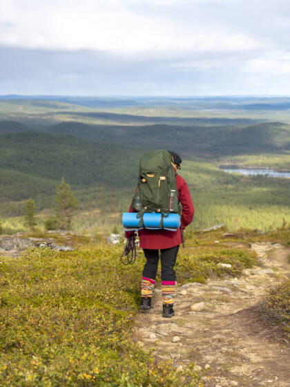 Vaeltaja kävelee rinkka selässä Lapin tunturissa.