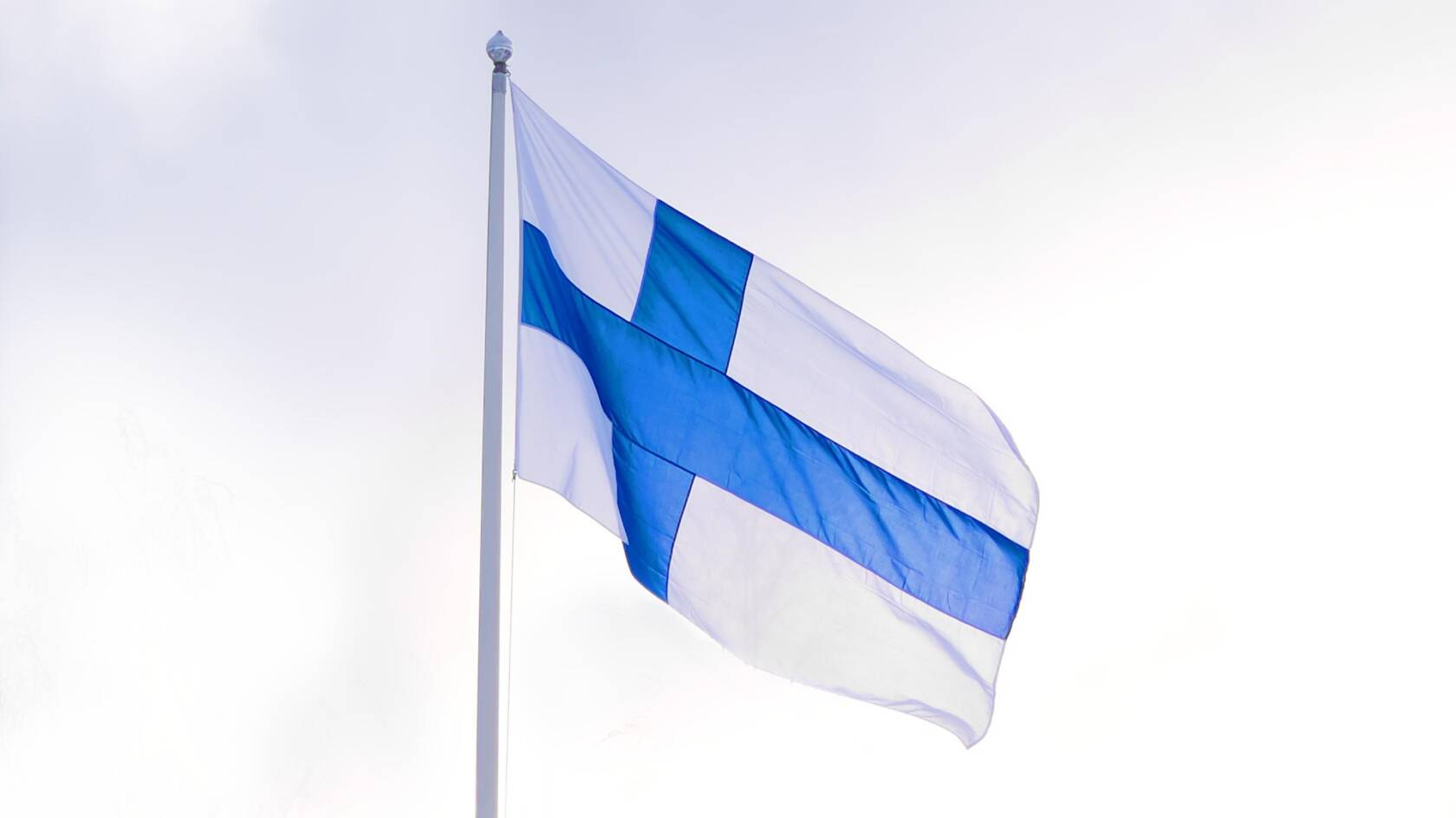 Suomen lippu liehuu lipputangossa.